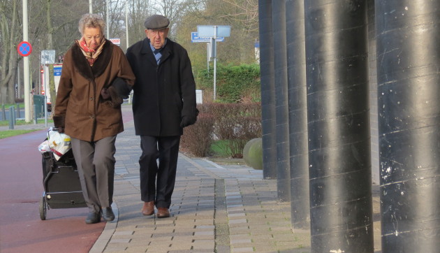 Twee bejaarde mensen wandelen op straat
