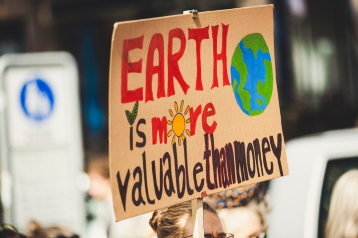klimaatprotest bord met tekst: earth is more valuable than money